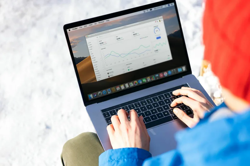 Person reviewing social media analytics data on a laptop screen with notes open on a desk
