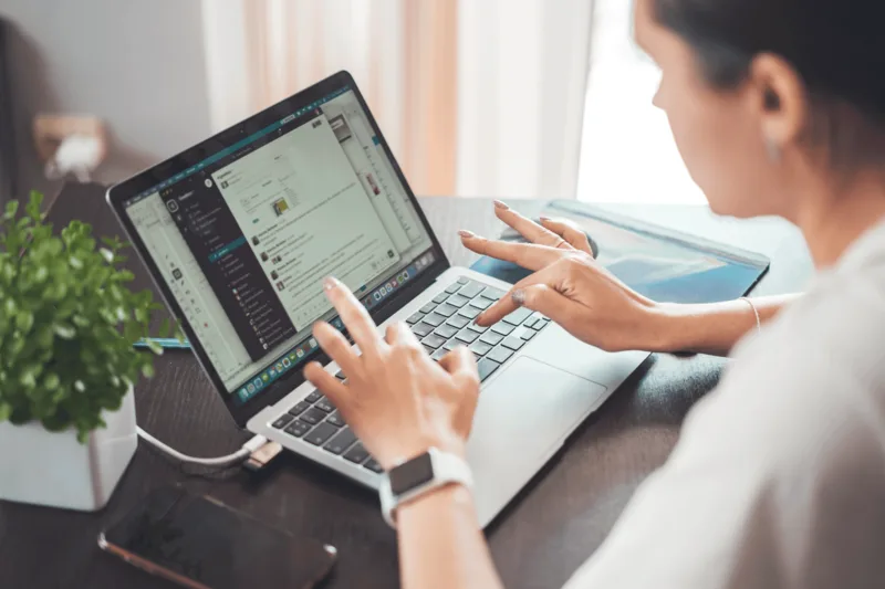 Professional reviewing a list of LinkedIn connections on a laptop in a well-lit home office