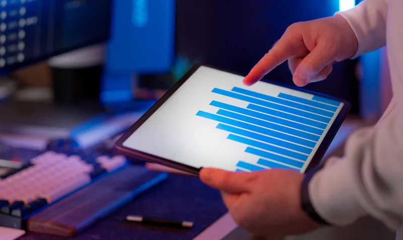 A business professional reviewing analytics data on a tablet in an office setting
