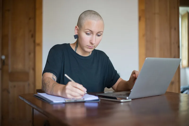 Solo creator filming a casual &ldquo;day in my life&rdquo; Story on their phone at a home office desk, showing the real behind-the-scenes of content creation