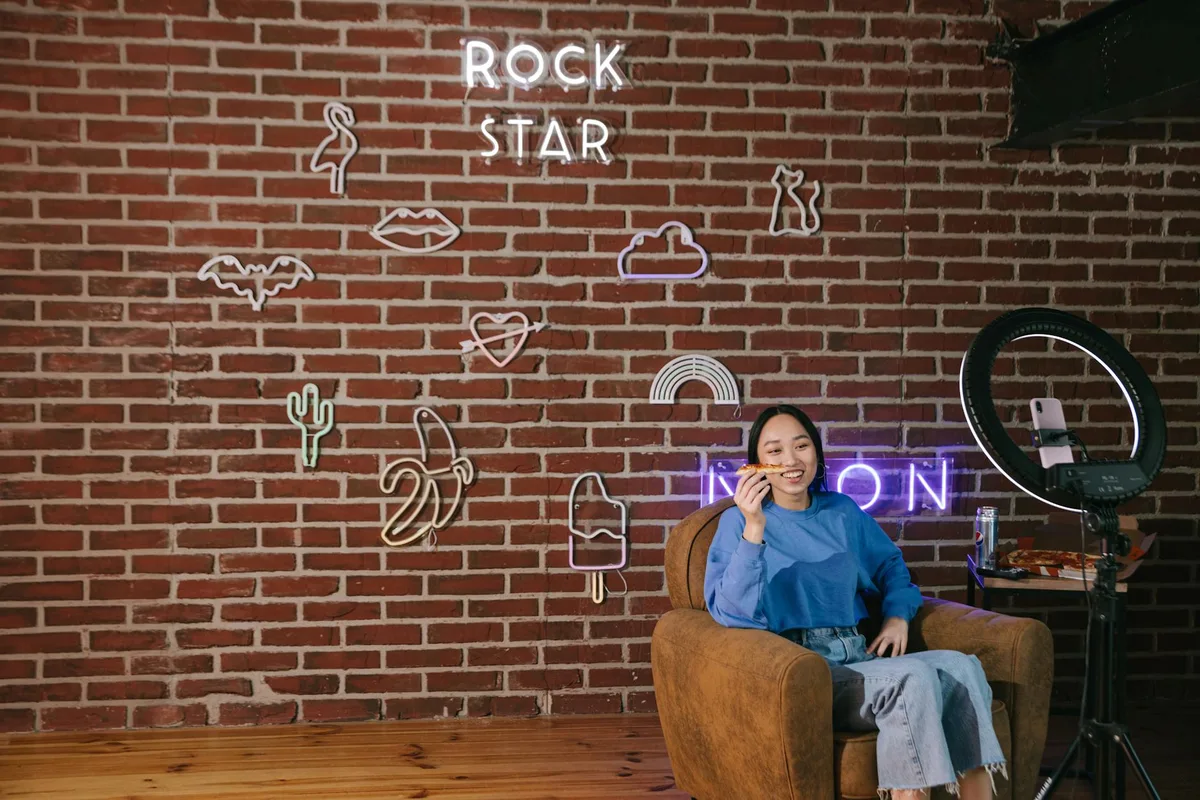 Solo creator sitting at a desk reviewing Instagram Story analytics on their phone, planning content for business growth