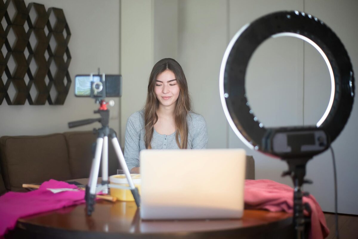 Young woman filming an Instagram Reel with a smartphone and ring light — the right format for what to post on Instagram