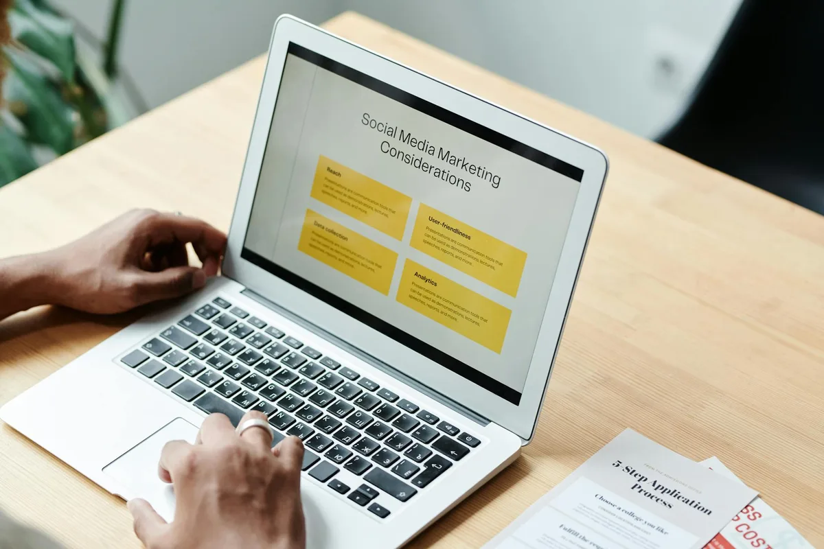Person using a laptop to review social media content and plan LinkedIn posts