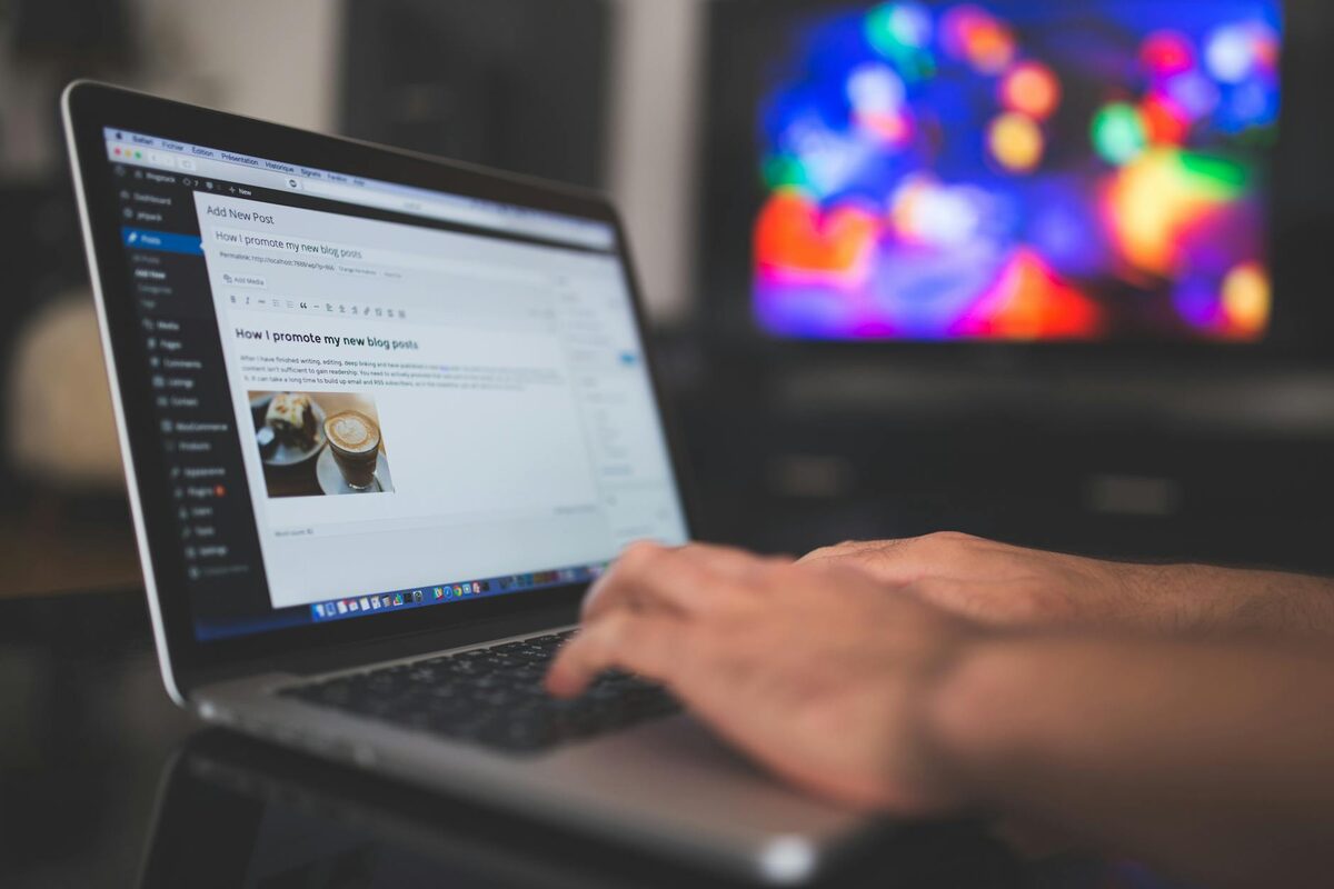 Hands typing on a laptop drafting a LinkedIn post with a structured hook, body, and call to action