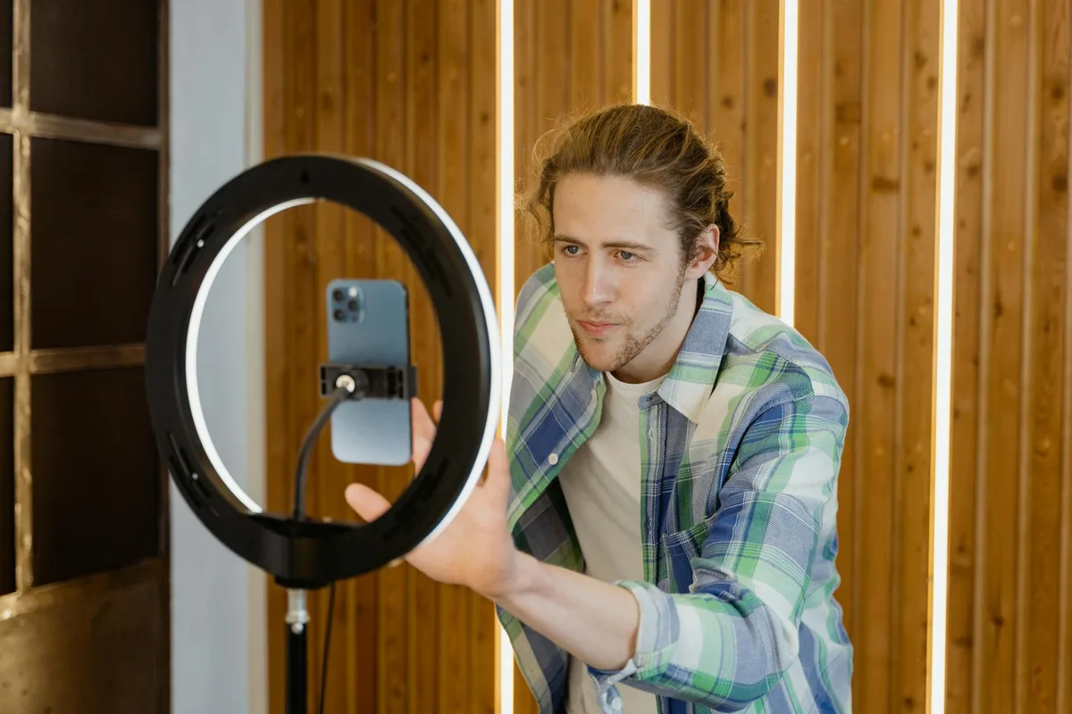 Man setting up smartphone with ring light for social media video recording — TikTok content strategy for solo creators