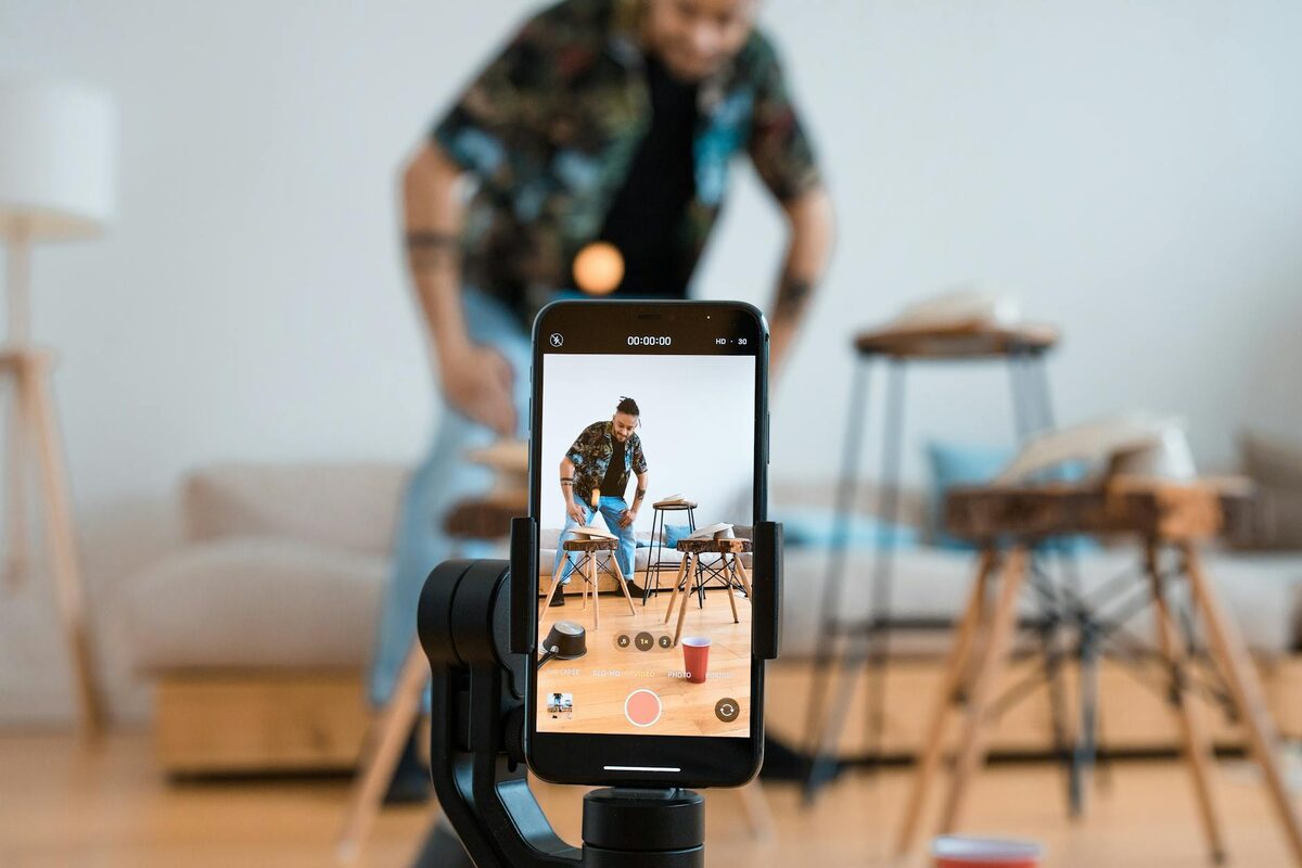 Man recording a TikTok video with a smartphone on a tripod in a home studio — TikTok content ideas for solo creators