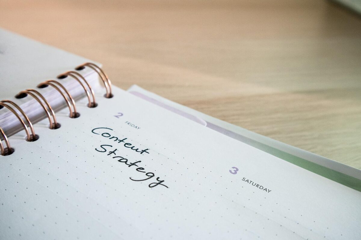 Notebook planner open to a &ldquo;Content Strategy&rdquo; page on a wooden desk — goal-based TikTok content strategy