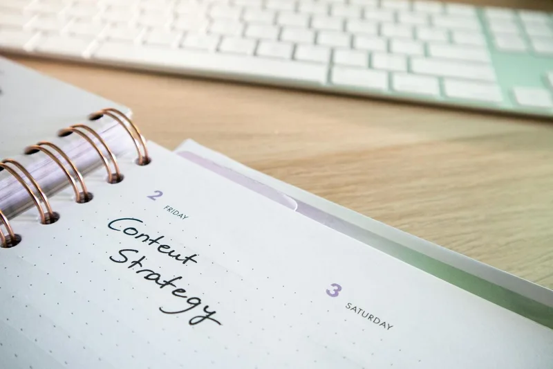 Creator reviewing content notes and analytics at a planning desk with notebook