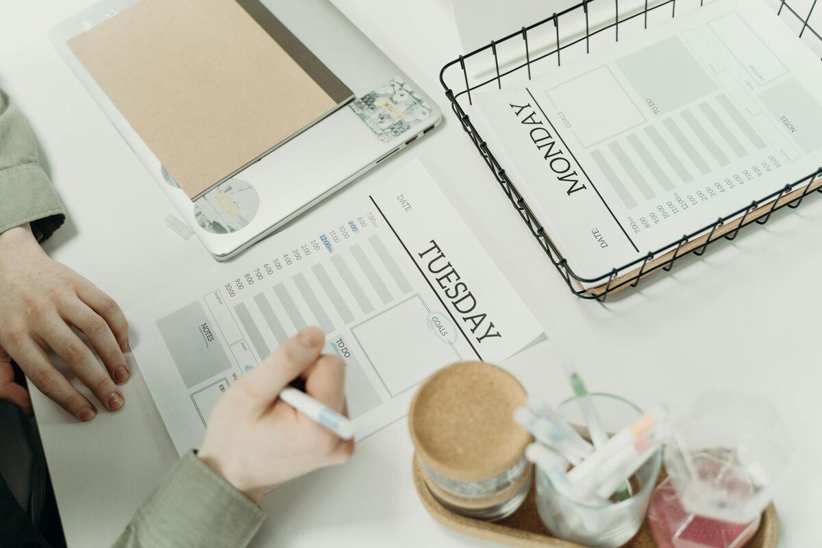 A professional organizing a weekly content plan using a schedule planner, representing the ideation-to-production workflow for solo creators