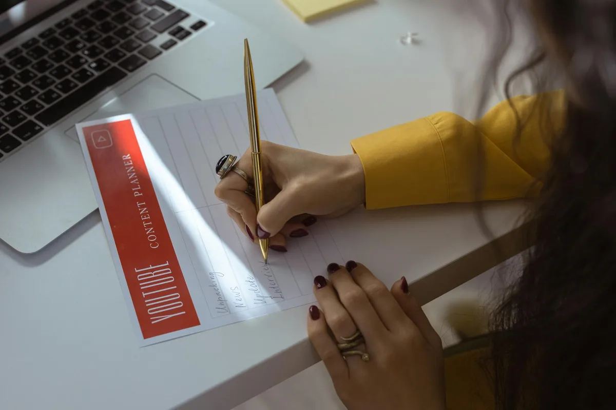 YouTube creator at a desk planning a content strategy on a laptop