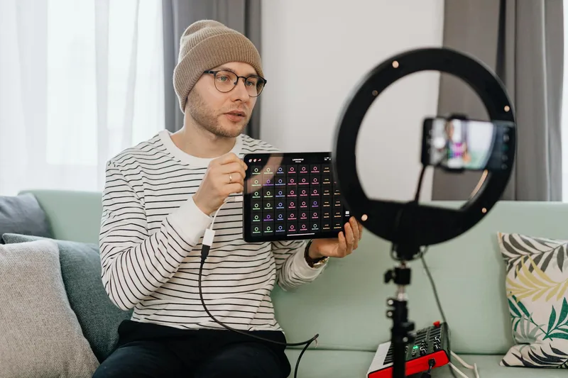 Solo creator filming a YouTube tutorial at a home desk setup with ring light