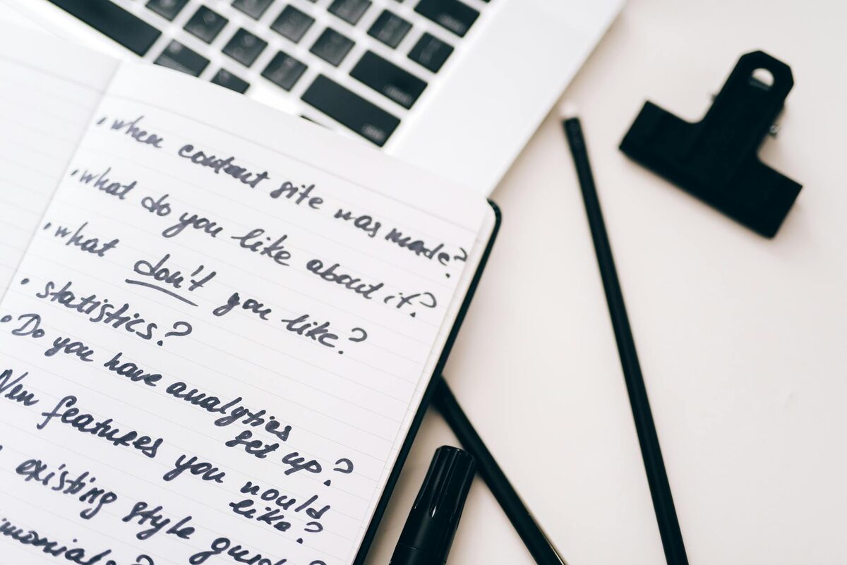 Open notebook with strategy planning notes and a laptop, illustrating ideas for a YouTube channel concept