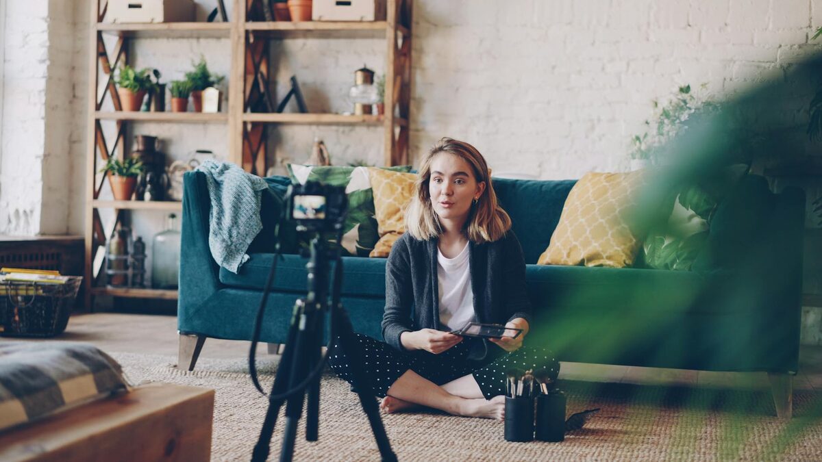 Woman filming a YouTube video at home in a cozy setup, representing YouTube video ideas for solo creators